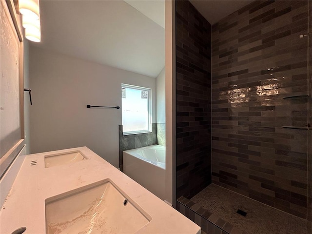 full bath with a sink, tiled shower, a garden tub, and lofted ceiling