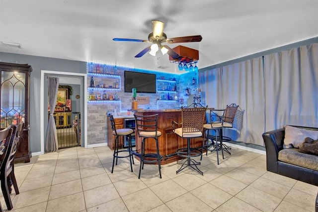 bar with ceiling fan and light tile patterned flooring