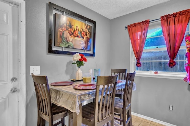 tiled dining space featuring a textured ceiling