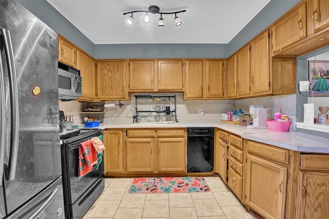 kitchen featuring light tile patterned floors, sink, and black appliances