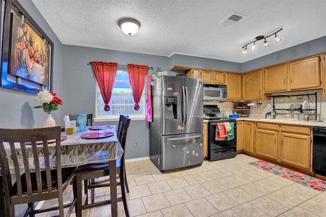 kitchen with a textured ceiling, black appliances, and light tile patterned flooring