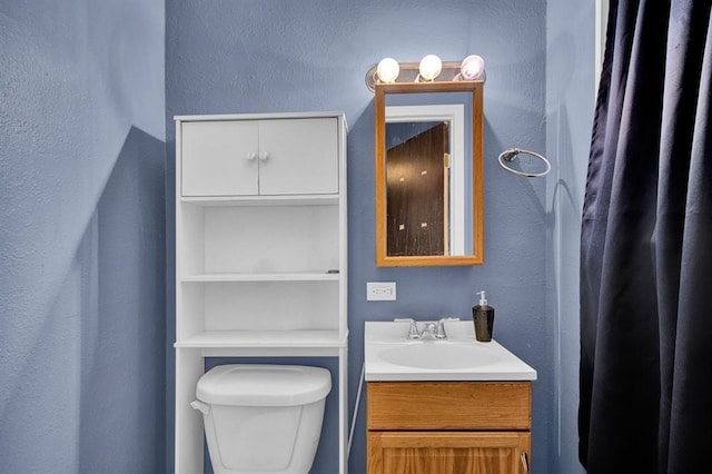 bathroom featuring toilet and vanity