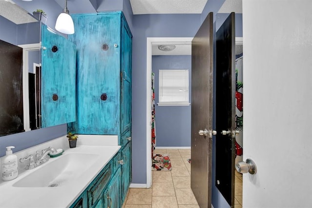 bathroom featuring vanity, tile patterned flooring, and a textured ceiling