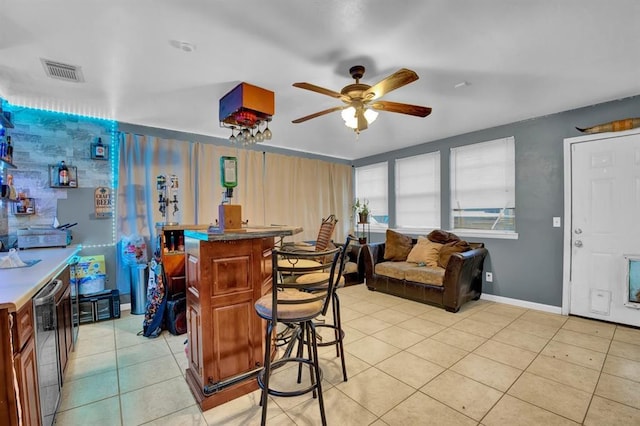 kitchen with ceiling fan, light tile patterned floors, and a center island