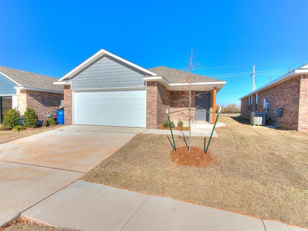 view of front of home with a garage and central air condition unit