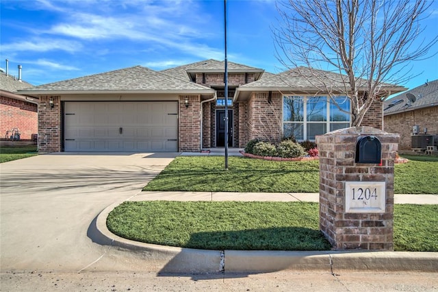 view of front of property featuring a garage, a front yard, and central air condition unit