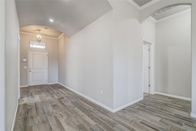 entrance foyer with crown molding and light hardwood / wood-style floors