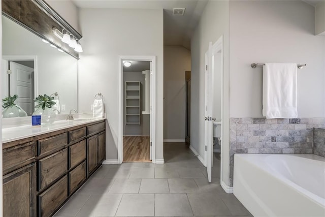 bathroom featuring tile patterned floors, a bathtub, and vanity