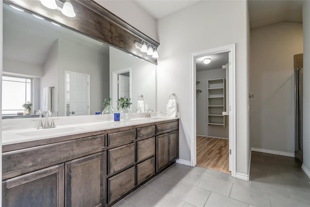 bathroom featuring vanity, tile patterned flooring, and vaulted ceiling