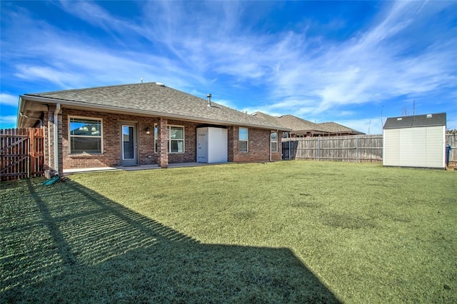 rear view of house featuring a yard and a storage unit