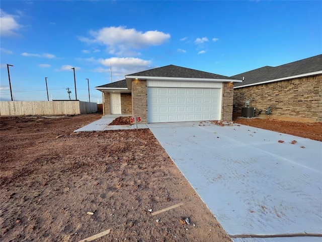 single story home featuring a garage and central air condition unit