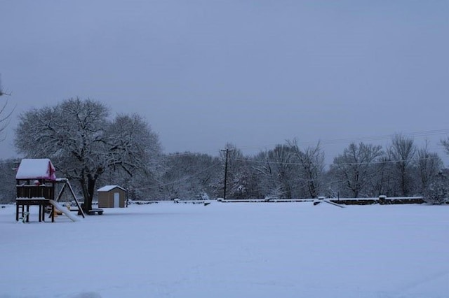 snowy yard featuring a shed