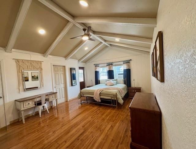 bedroom featuring ceiling fan, dark wood-type flooring, and vaulted ceiling with beams