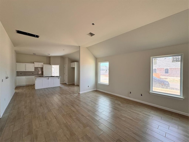 unfurnished living room with lofted ceiling