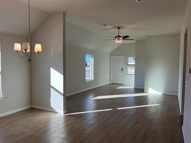 interior space featuring vaulted ceiling and ceiling fan with notable chandelier