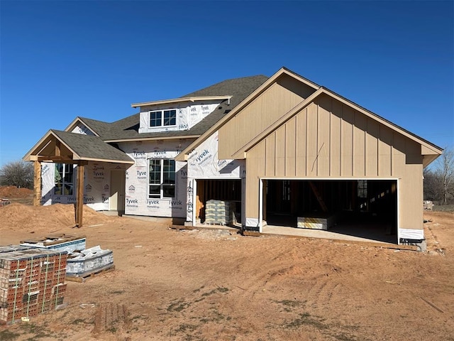 unfinished property with a shingled roof and an attached garage