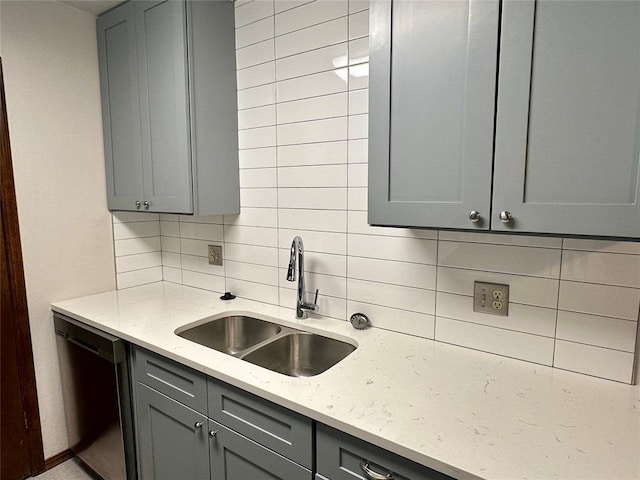 kitchen featuring decorative backsplash, gray cabinetry, and dishwasher