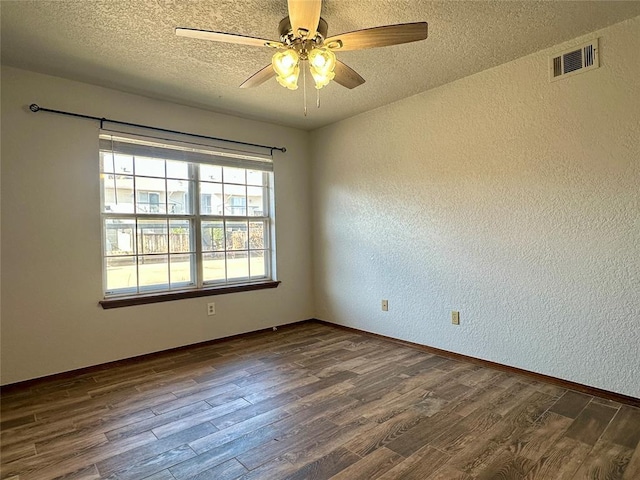 empty room featuring a textured ceiling, ceiling fan, and dark hardwood / wood-style floors