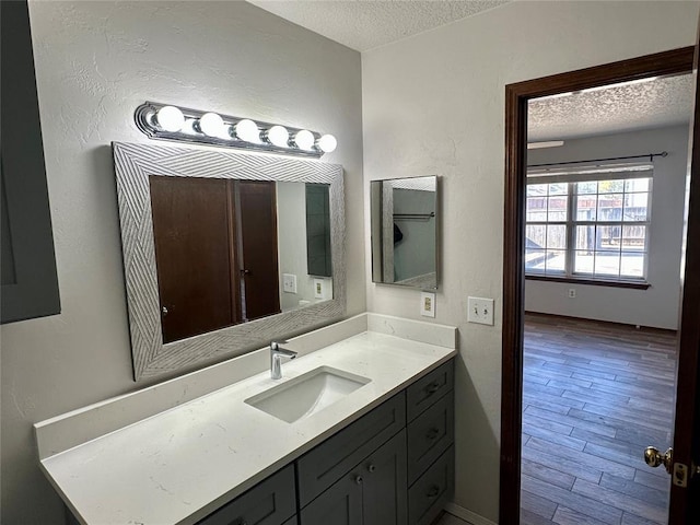 bathroom featuring hardwood / wood-style flooring, a textured ceiling, and vanity