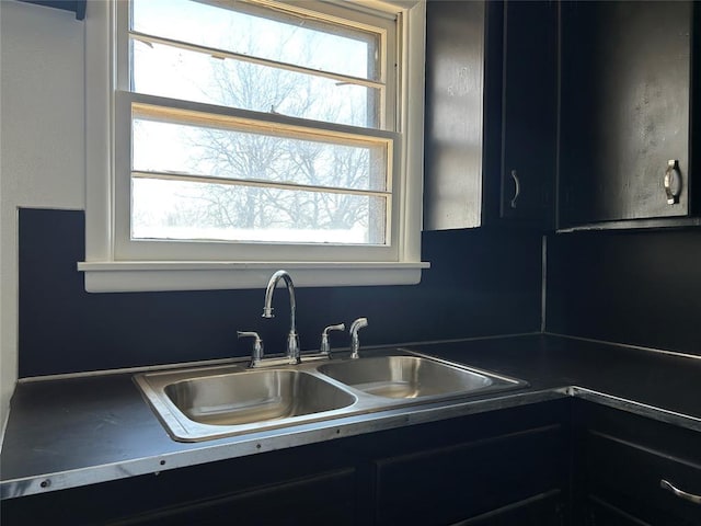 kitchen with dark cabinetry and a sink