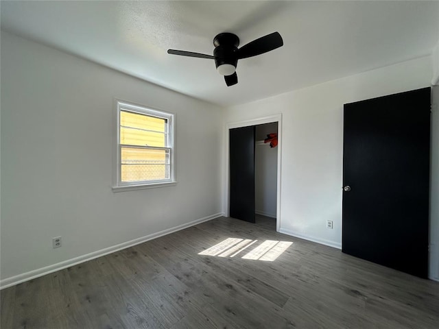 unfurnished bedroom featuring a closet, ceiling fan, baseboards, and wood finished floors