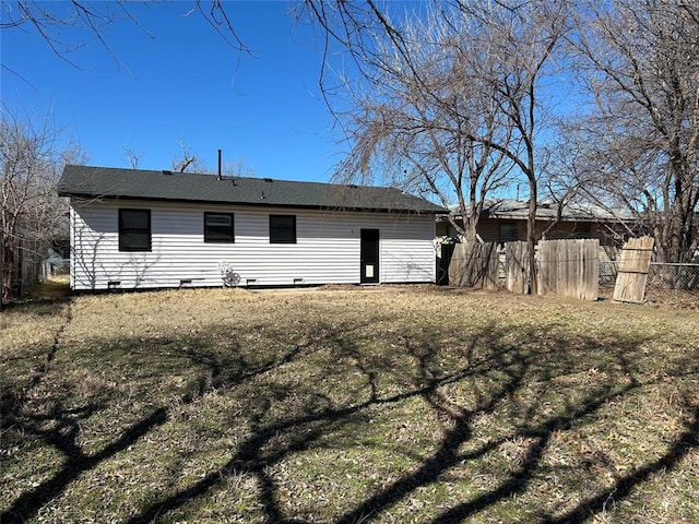 rear view of house featuring crawl space and fence