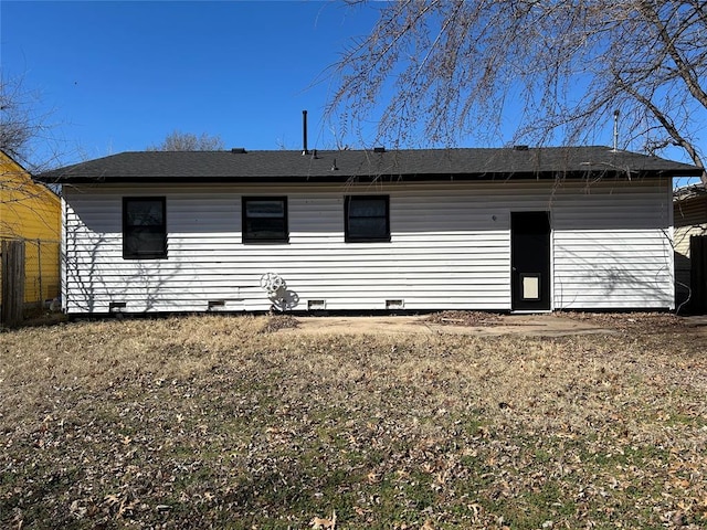 rear view of house featuring crawl space and fence