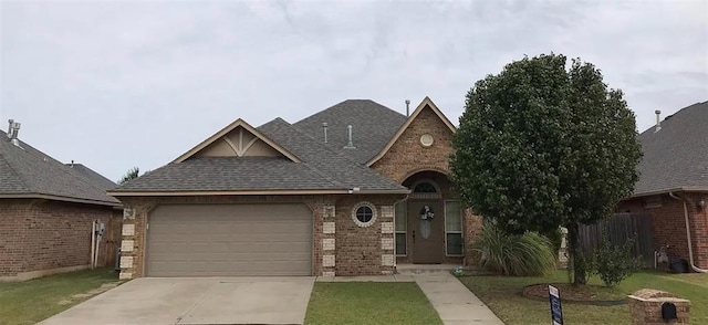 view of front of house featuring brick siding, a front yard, an attached garage, and a shingled roof