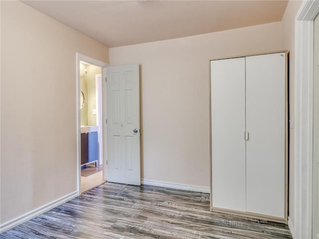 unfurnished bedroom with hardwood / wood-style flooring and a closet