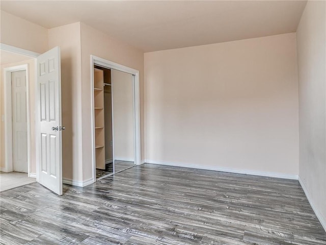 unfurnished bedroom with dark hardwood / wood-style floors and a closet