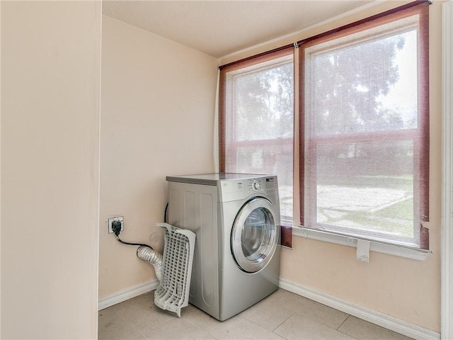 laundry room featuring plenty of natural light, light tile patterned flooring, and washer / dryer