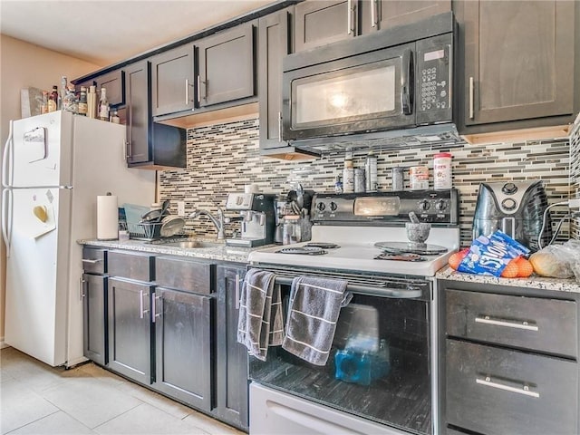 kitchen featuring white appliances, light tile patterned floors, backsplash, and light stone counters