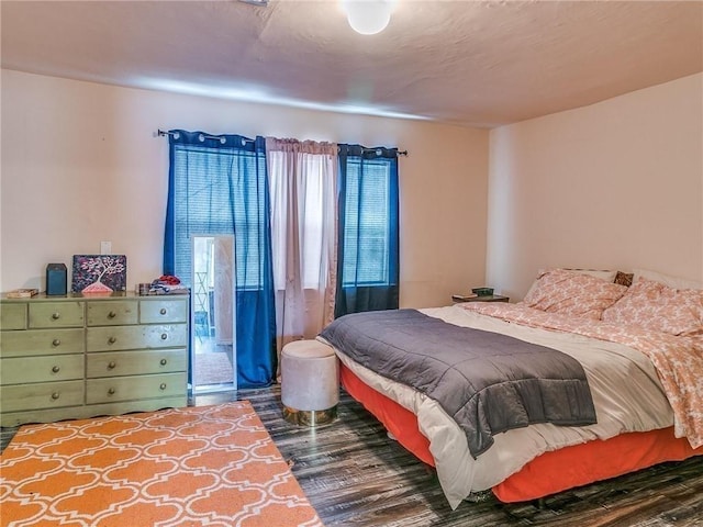 bedroom with dark hardwood / wood-style flooring