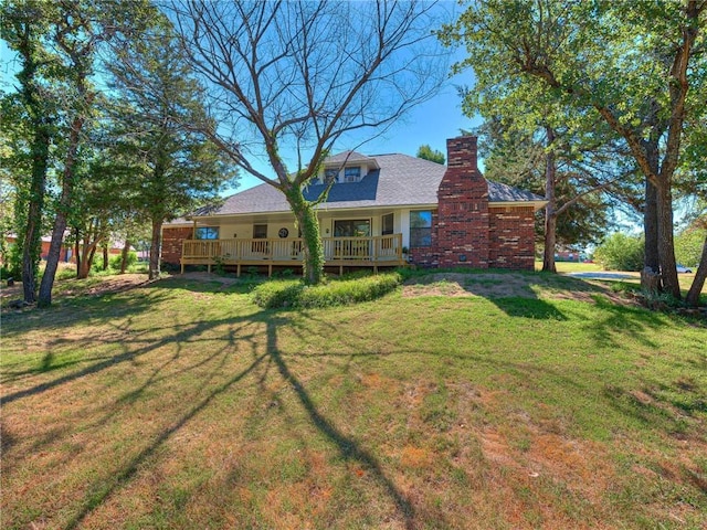 back of house featuring a deck and a lawn