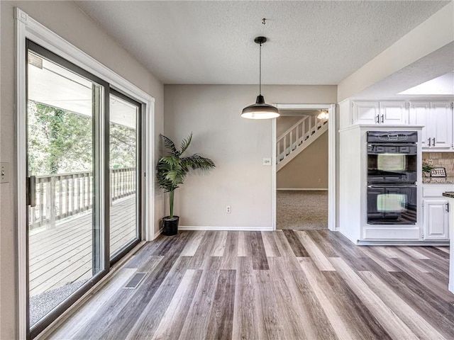 interior space featuring a textured ceiling and light hardwood / wood-style flooring