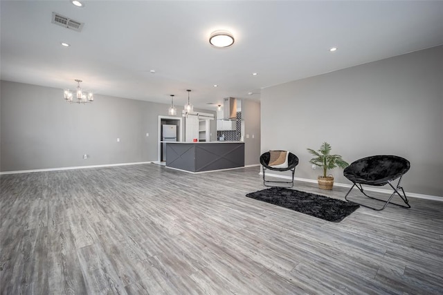 sitting room with hardwood / wood-style flooring and a notable chandelier