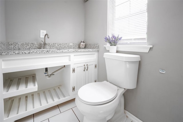 bathroom featuring toilet, tile patterned floors, and sink