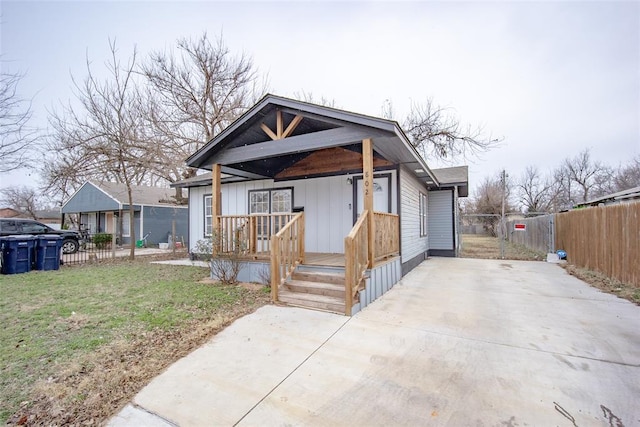 bungalow-style home featuring covered porch and a front lawn