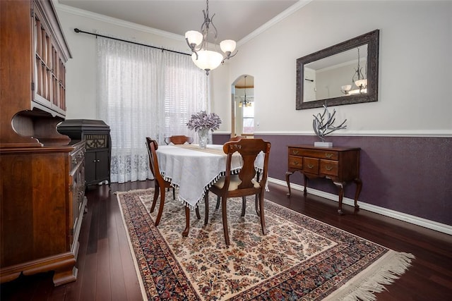 dining room with arched walkways, dark wood-type flooring, baseboards, and crown molding