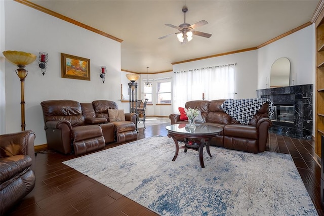 living area with dark wood-style floors, a premium fireplace, a ceiling fan, and crown molding