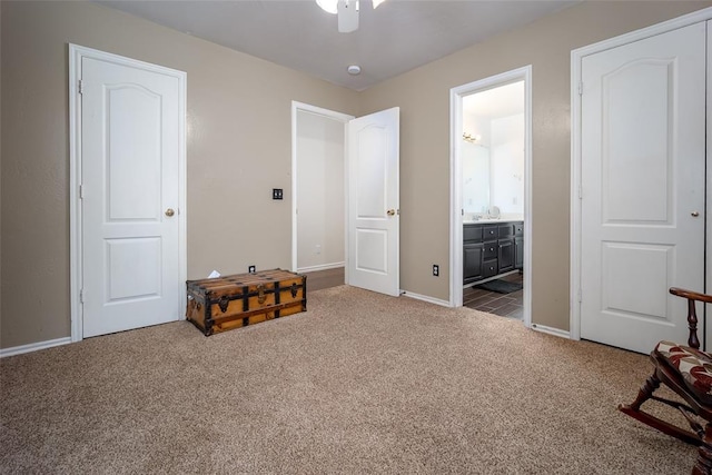 bedroom featuring dark colored carpet, connected bathroom, baseboards, and ceiling fan