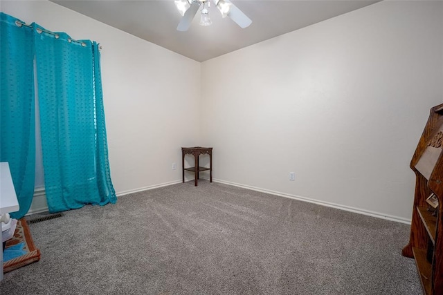 carpeted spare room with ceiling fan and baseboards