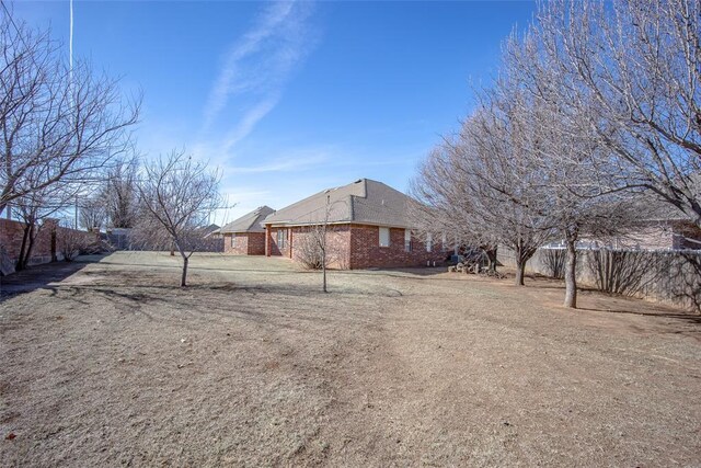 view of side of property with brick siding and fence