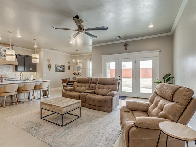 living room featuring ceiling fan, ornamental molding, and light wood-type flooring