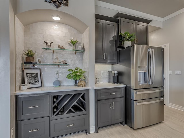 kitchen with light hardwood / wood-style floors, backsplash, stainless steel fridge, and gray cabinets