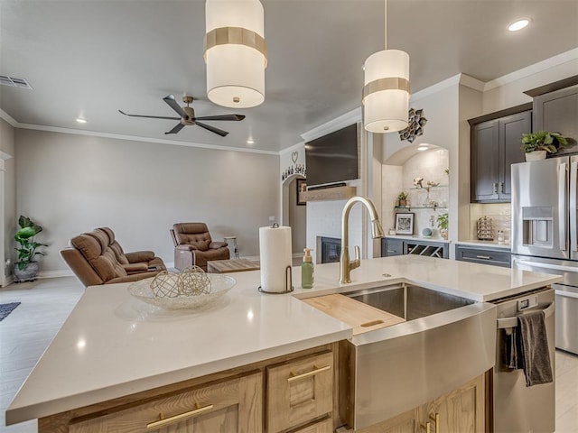 kitchen with light wood-type flooring, ceiling fan, stainless steel appliances, and light brown cabinetry