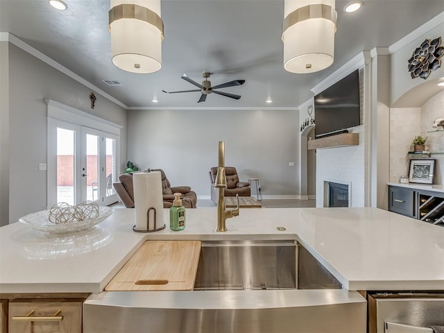 kitchen featuring backsplash, a fireplace, french doors, crown molding, and sink