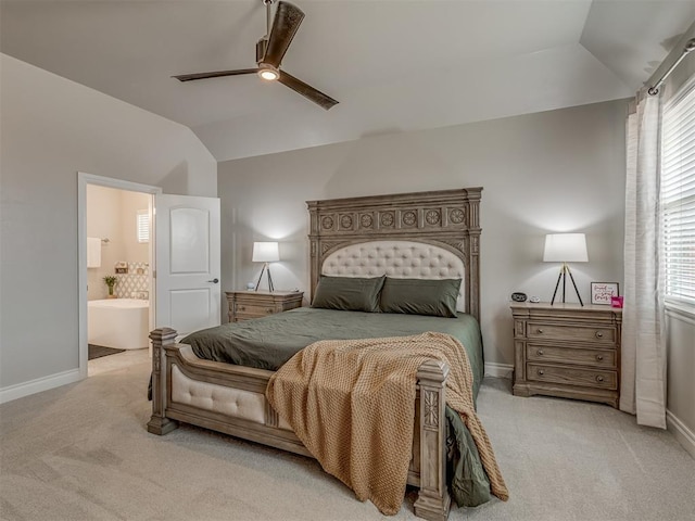 bedroom with ceiling fan, light colored carpet, ensuite bathroom, and lofted ceiling