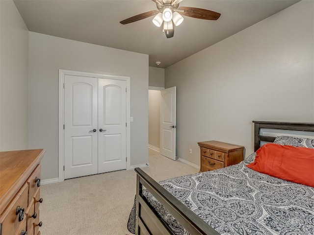 bedroom featuring ceiling fan, light colored carpet, and a closet