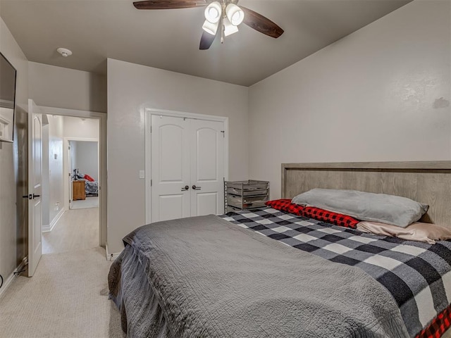 bedroom with ceiling fan, a closet, and light carpet